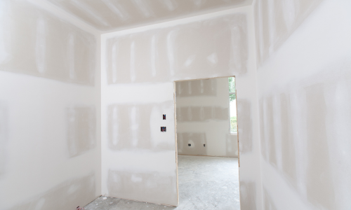 A room with new drywall, ready for renovation.