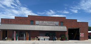 Brick building with 'J.P. Lumber' sign under a blue sky