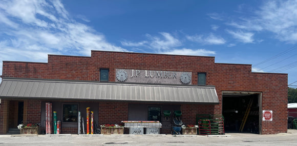Brick building with 'J.P. Lumber' sign under a blue sky
