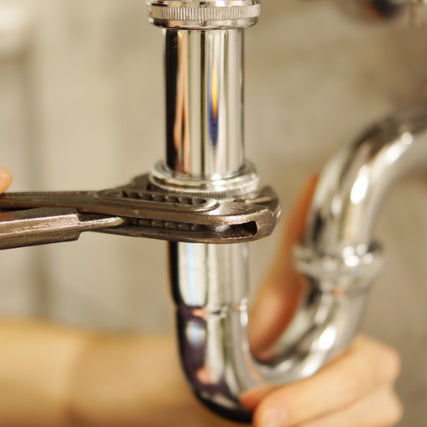 Plumbing SuppliesA wrench tightening a pipe.