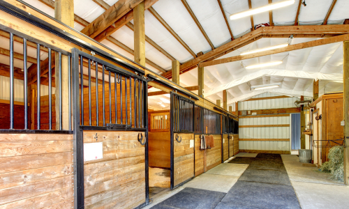 The interior of a pole barn with barn stalls.