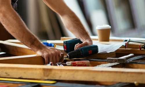 A power drill being used on a wood structure.